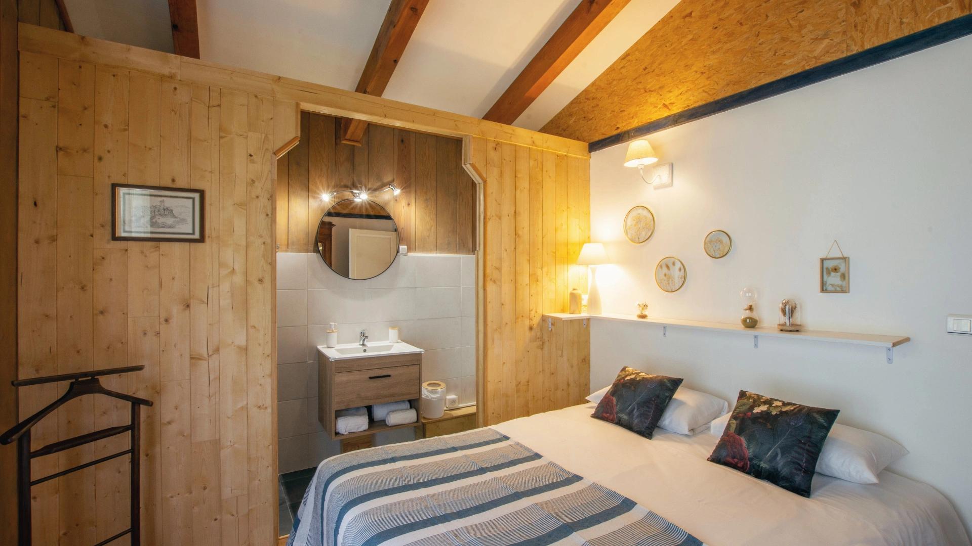 Ambiance chaleureuse et épurée dans une chambre avec balcon au cœur de la nature