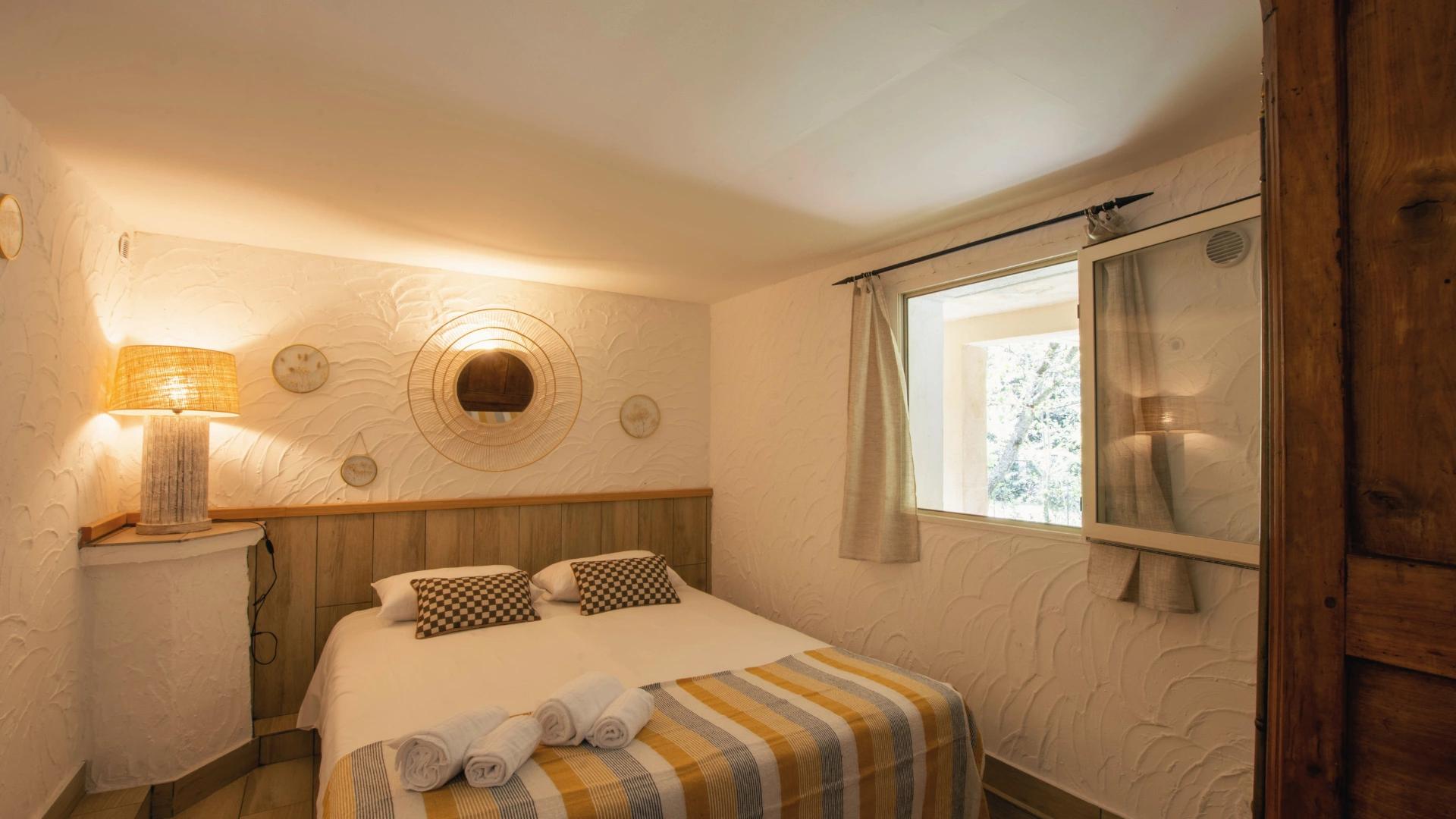 Espace nuit avec lit double, rangements et décoration naturelle