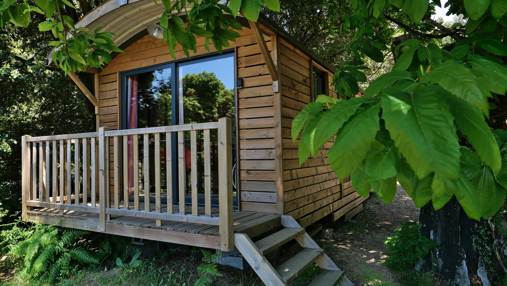 Terrasse aménagée de la roulotte "ALTA ROCCA" offrant une vue apaisante sur la nature environnante au Camping Bavella Vista