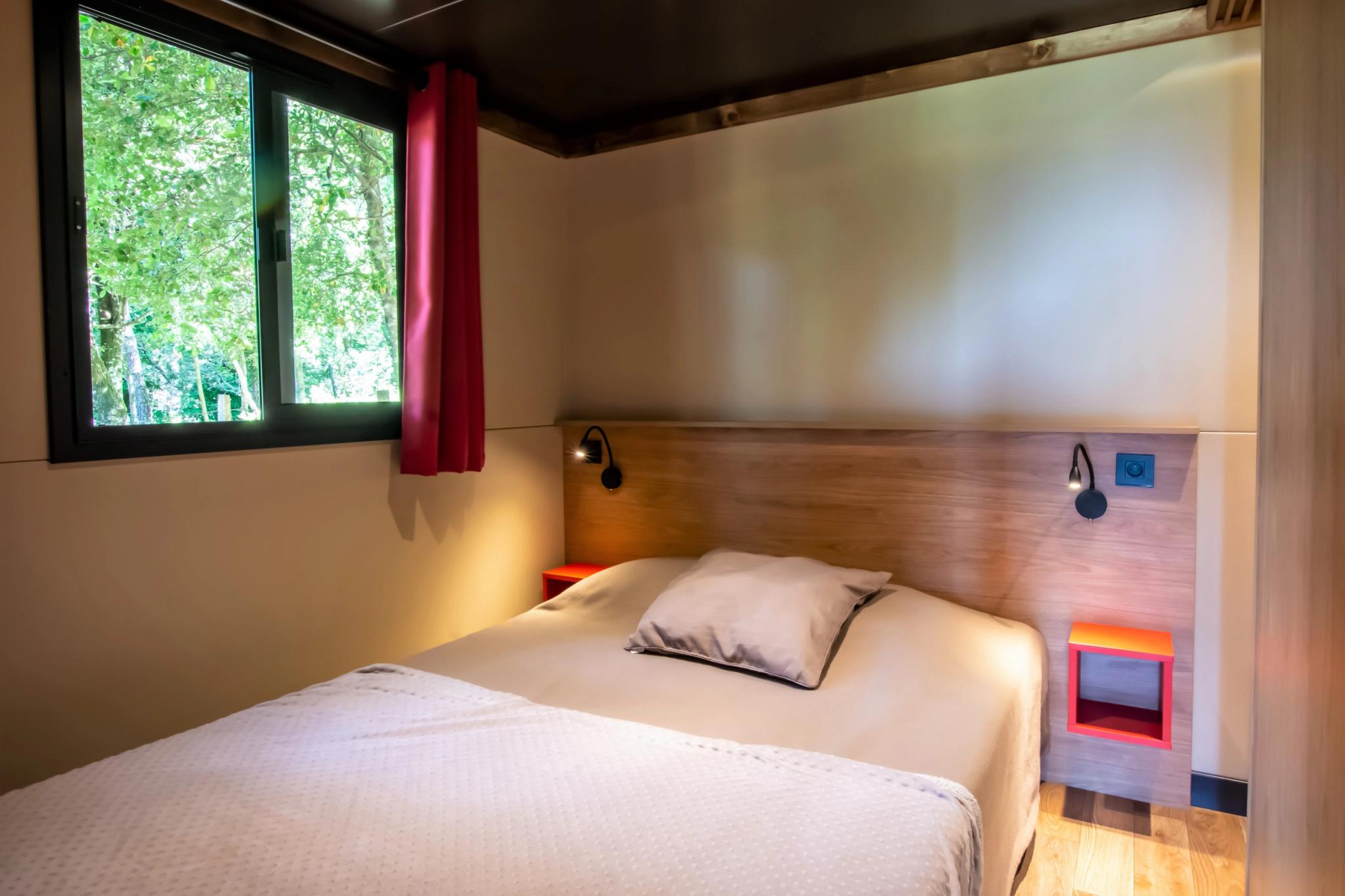 Chambre principale avec lit double dans la roulotte "ALTA ROCCA" au Camping Bavella Vista en Corse-du-Sud